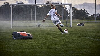 Mähroboter auf dem Fußballplatz mäht automatisch den Rasen.